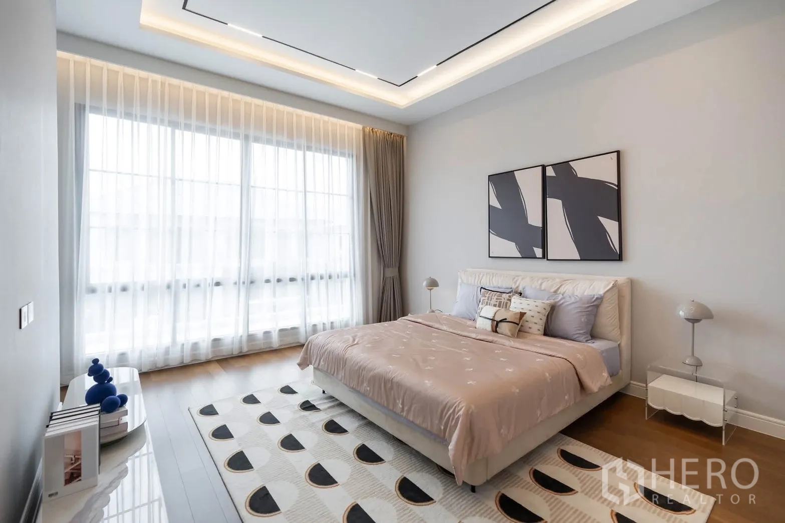 Detached House for rent or sale in Bang Kapi, Bangkok - Airy bedroom with king bed, modern ceiling lighting, and sheer floor-to-ceiling curtains.