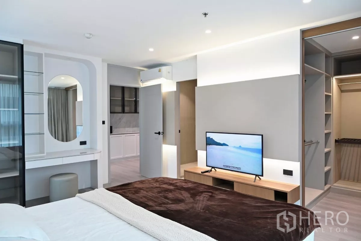 คอนโด ให้เช่าในWatthana, Bangkok - ห้องนอนมาสเตอร์พร้อมชั้นวางทีวี แสงไฟซอฟต์ไลท์ และทางเข้าตู้เสื้อผ้าแบบวอล์กอิน