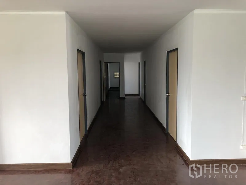Factory for rent in Lam Luk Ka, Pathum Thani - Office corridor with multiple rooms on both sides and wood‑tone flooring.