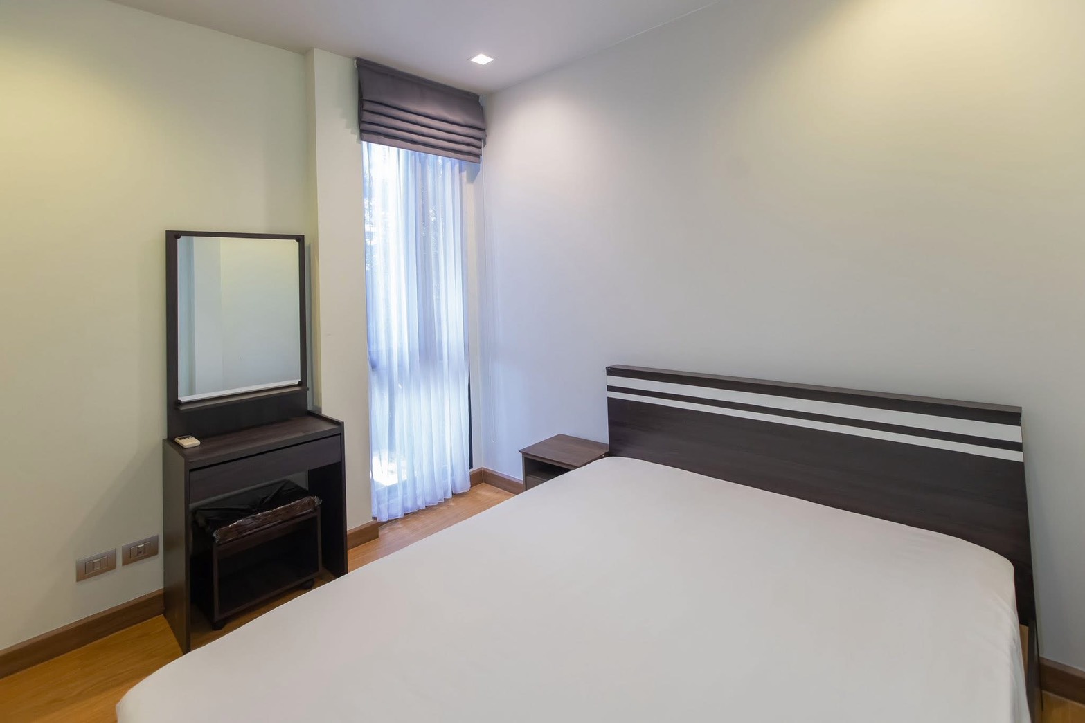 Detached House for rent in Lat Phrao, Bangkok - Guest bedroom with tall window, roman shade, and dressing table.