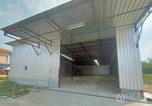 Warehouse for rent in Mueang Samut Sakhon, Samut Sakhon - Front view of the warehouse showing a large entry opening under an extended metal canopy.