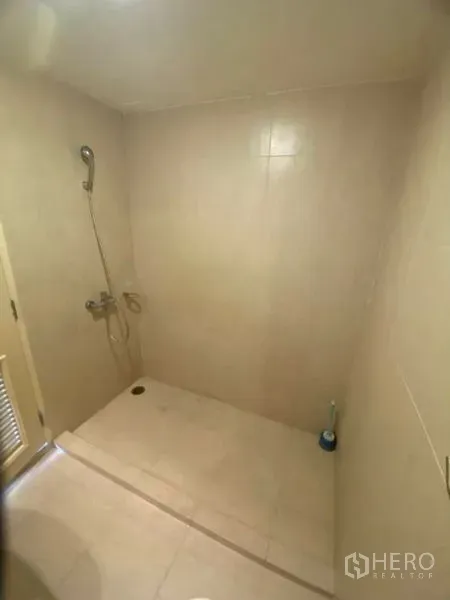 Condominium for rent in Watthana, Bangkok - Walk-in shower with handheld showerhead and beige wall tiles.