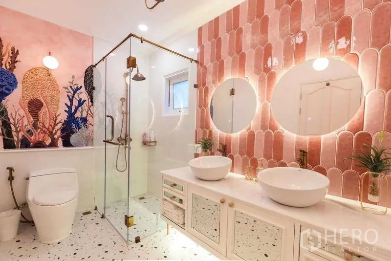 Townhouse for rent in Lat Phrao, Bangkok - Bathroom with pink scalloped tiles, glass shower enclosure, double round basins and terrazzo floor.