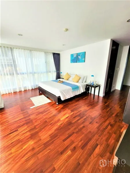 Condominium for rent in Bang Rak, Bangkok - Spacious bedroom with king bed, bedside tables, and wall-to-wall glazing.