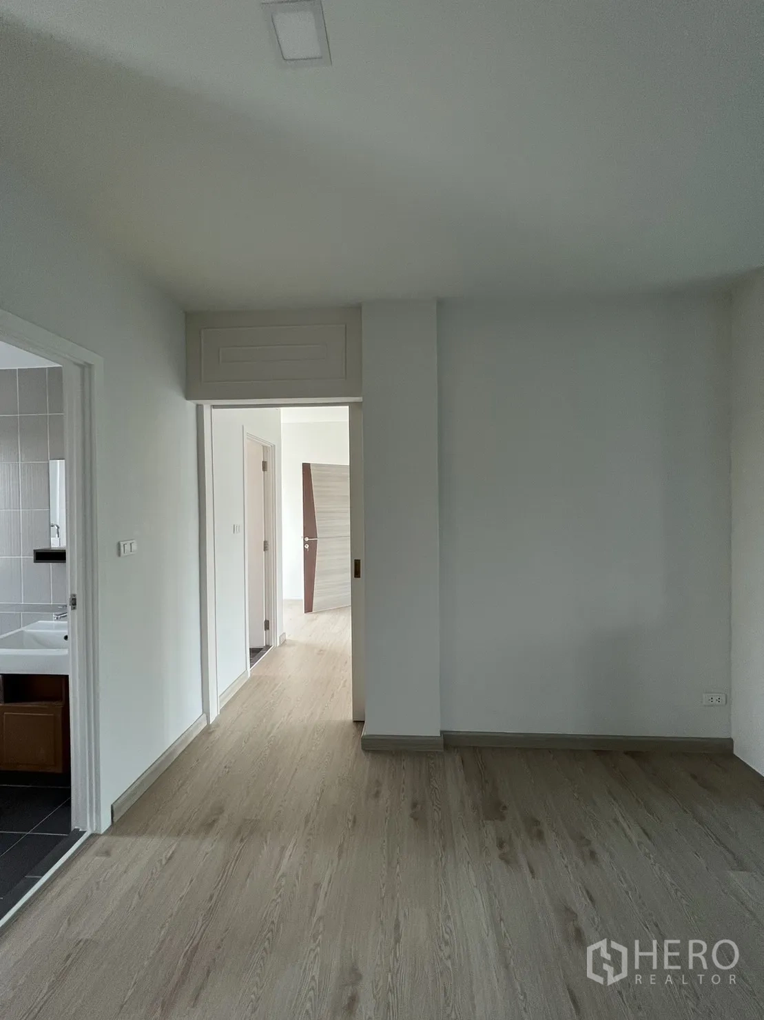 Home Office for rent in Bang Phli, Samut Prakan - Hallway with wood flooring leading to internal rooms and bathroom.