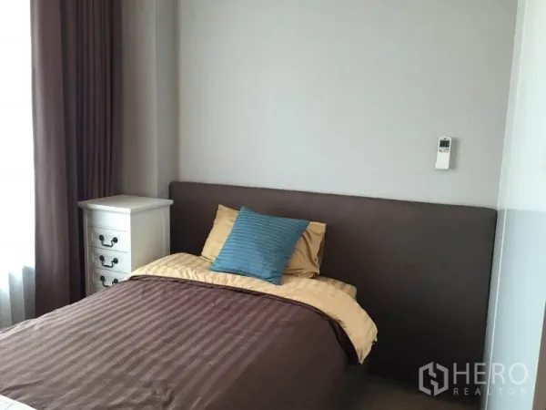 公寓 出租在Ratchathewi, Bangkok - 卧室配单人床、床边柜与大窗帘，采光充足。