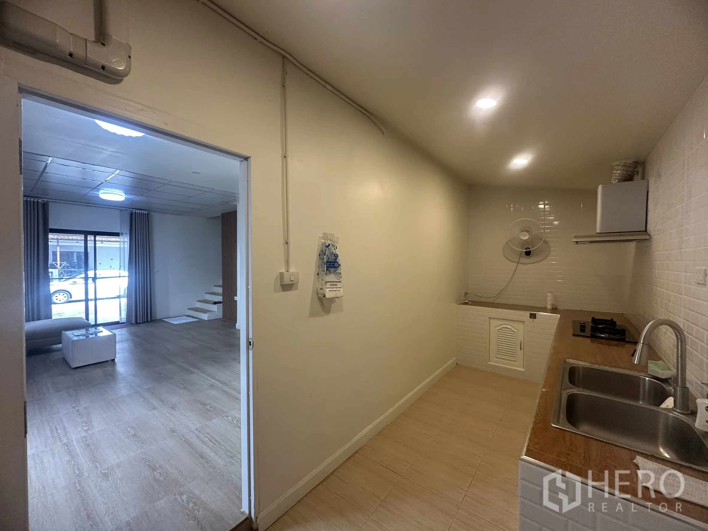 Townhouse for sale in Lam Luk Ka, Pathum Thani - Enclosed kitchen with sink, counter space, cooktop, and range hood.
