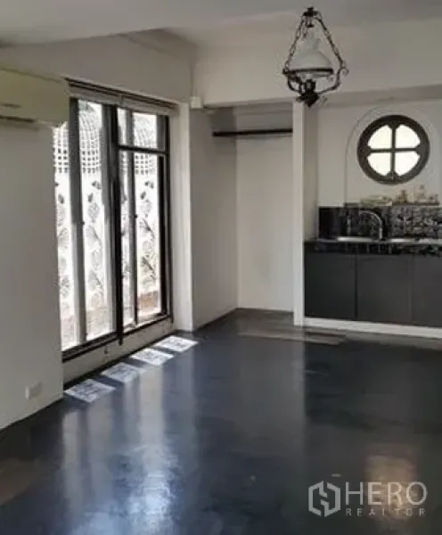 带办公室的家 出售在Wang Thonglang, Bangkok - 一层开放空间，配紧凑茶水间、圆形窗口与通向小露台的推拉玻璃门。
