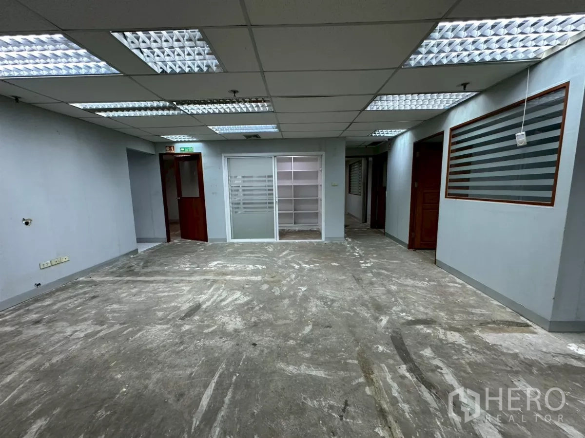 办公空间 出租在Khlong Toei, Bangkok - 走廊与开放区，滑动玻璃入口、内置置物架和多扇门。