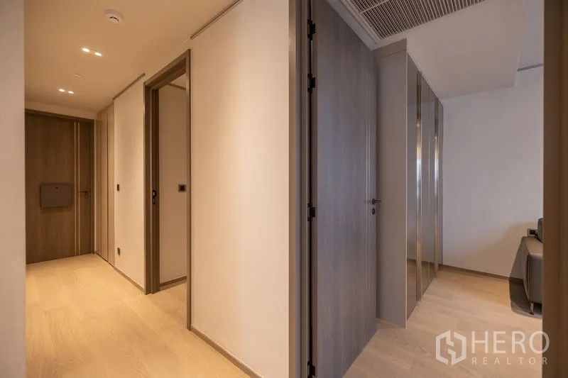 Condominium for rent in Pathum Wan, Bangkok - Corridor to bedrooms with wood doors and concealed storage.
