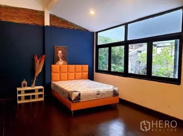 บ้าน ให้เช่าในPathum Wan, Bangkok - ห้องนอนกว้าง มีหน้าต่างบานใหญ่ ผนังสีน้ำเงิน เตียงเบาะสีส้ม