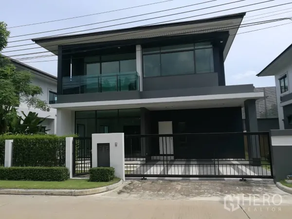 บ้าน ให้เช่าในBang Kapi, Bangkok - บ้านเดี่ยวสองชั้นสไตล์โมเดิร์น พร้อมรั้วและโรงจอดรถ ระเบียงและกระจกบานใหญ่ในโครงการร่มรื่น