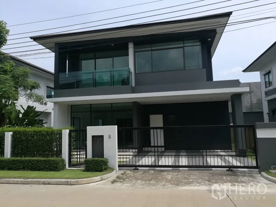 บ้าน ให้เช่าในBang Kapi, Bangkok - บ้านเดี่ยวสองชั้นสไตล์โมเดิร์น พร้อมรั้วและโรงจอดรถ ระเบียงและกระจกบานใหญ่ในโครงการร่มรื่น
