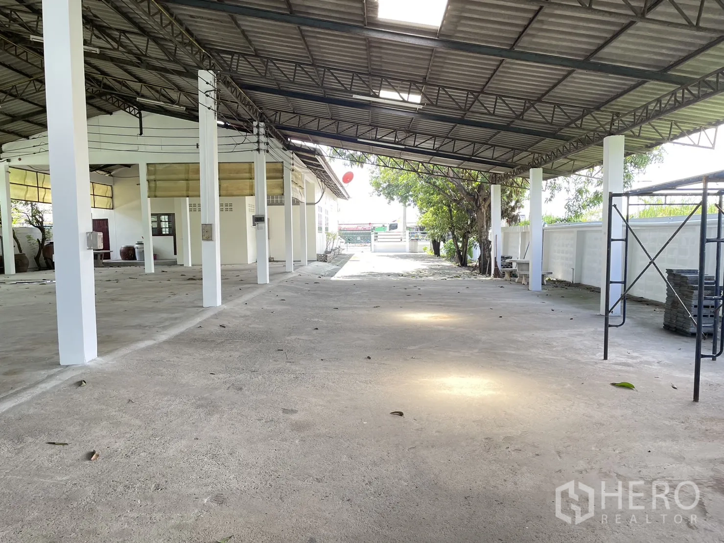 工厂 出租或出售在Pathum Thani - 宽阔带顶工作区，立柱引向临街大门。