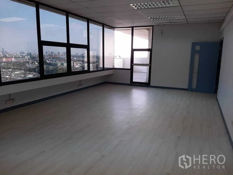 Office Space for rent in Khlong Toei, Bangkok - Bright office room with window wall and a door to a small balcony area.