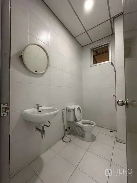 Factory for rent in Khlong Luang, Pathum Thani - Clean tiled bathroom with toilet, sink, and shower.