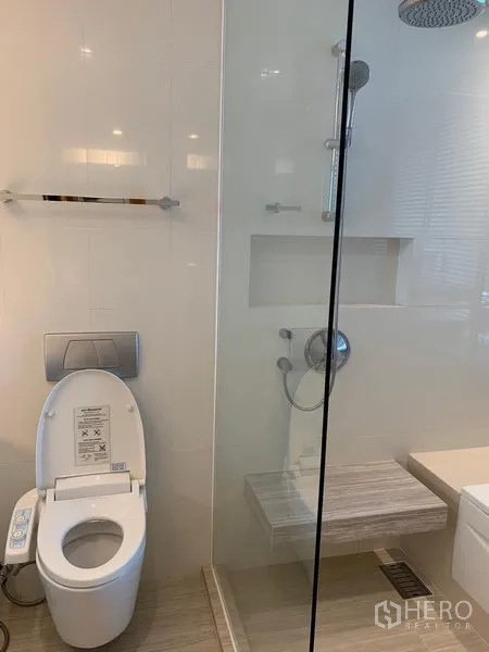 公寓 出租在Watthana, Bangkok - 浴室配玻璃淋浴间、顶喷花洒和智能坐便器。