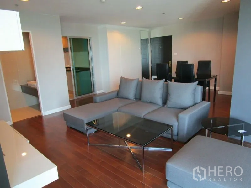 คอนโด ขายในHuai Khwang, Bangkok - ห้องนั่งเล่นกว้าง โซฟาเข้ามุม โต๊ะกลางกระจก และไฟดาวน์ไลท์
