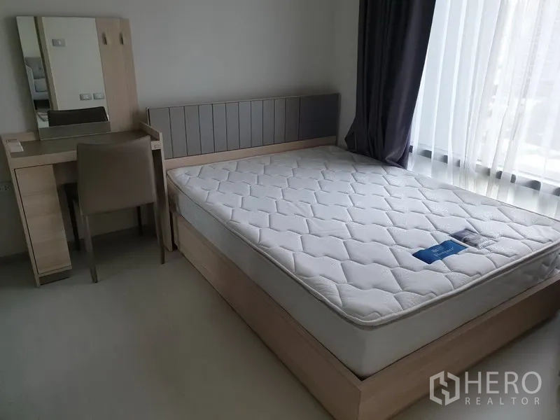 公寓 出租在Khlong Toei, Bangkok - 卧室配大窗、双人床与梳妆台，曼谷空堤区的现代公寓。