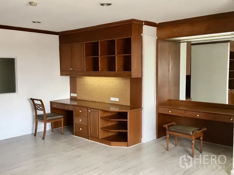 公寓 出租在Watthana, Bangkok - 卧室角落的内置木质书桌与搁架，大镜面与梳妆台。
