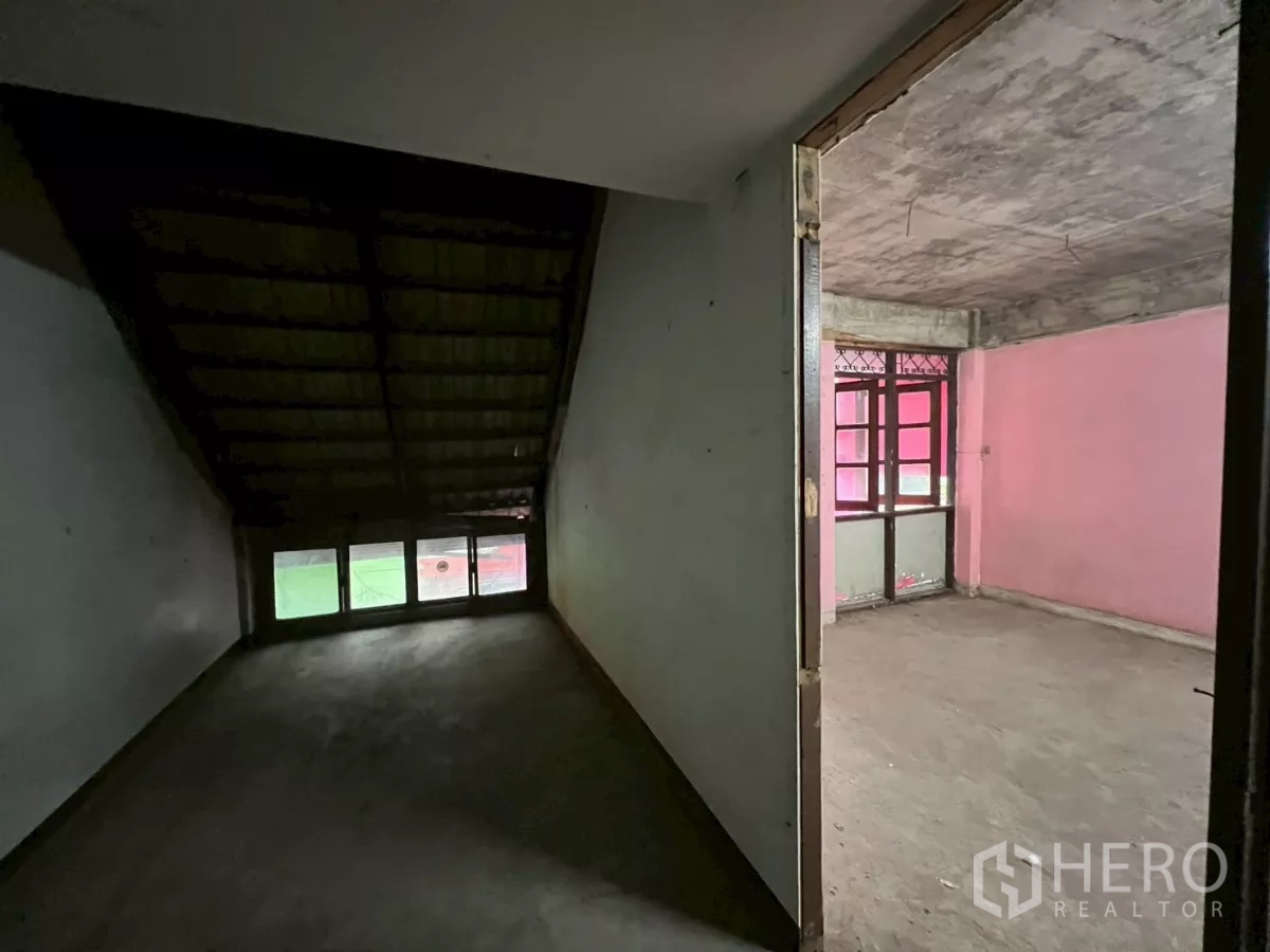 อาคารพาณิชย์ ให้เช่าในWatthana, Bangkok - โถงทางเดินเห็นห้องเพดานลาดชันติดกับห้องสีชมพูที่มีหน้าต่างและประตู