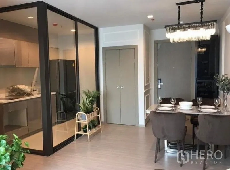 公寓 出租在Ratchathewi, Bangkok - 餐区与玻璃隔断厨房相邻的当代风空间。