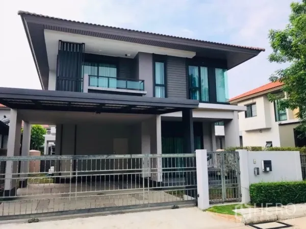 独立式住宅 出租或出售在Pathum Thani - 现代两层独栋别墅外观，带车棚与阳台