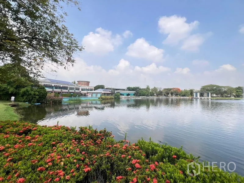 Detached House for rent - Community lake with waterfront clubhouse, landscaped flowers and blue sky reflections.
