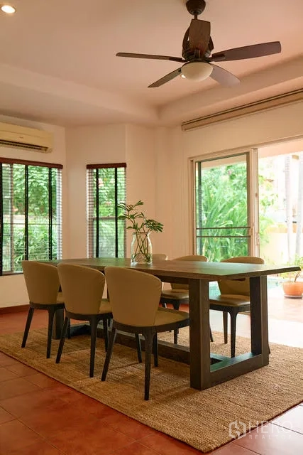 Detached House for rent in Watthana, Bangkok - Dining space with ceiling fan and garden views through sliding glass doors.