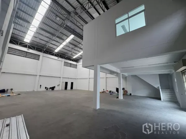 Factory for rent in Phra Samut Chedi, Samut Prakan - Open production floor showing mezzanine office box and stairway.