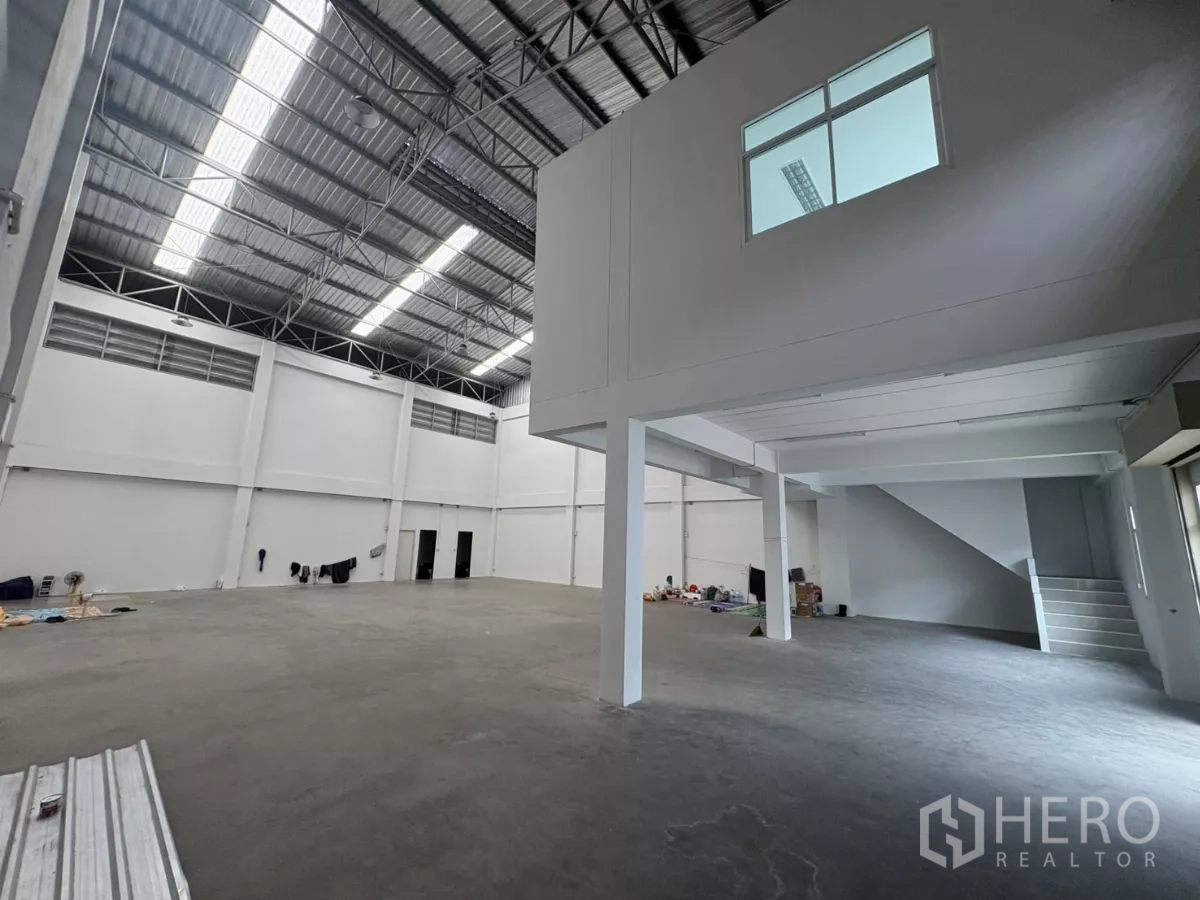 Factory for rent in Phra Samut Chedi, Samut Prakan - Open production floor showing mezzanine office box and stairway.