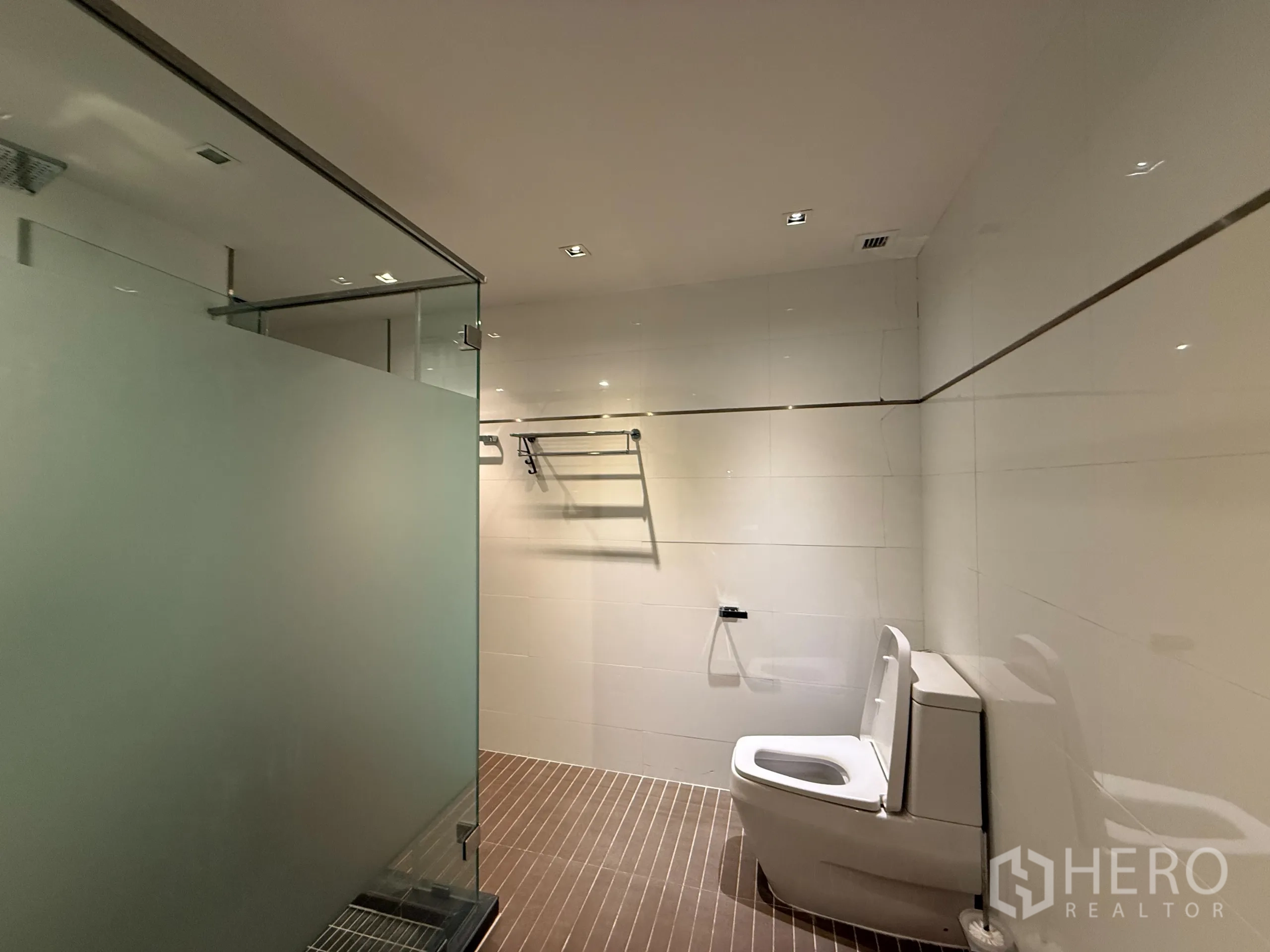 Condominium for rent in Phaya Thai, Bangkok - Spacious bathroom featuring frosted glass shower partition and toilet.