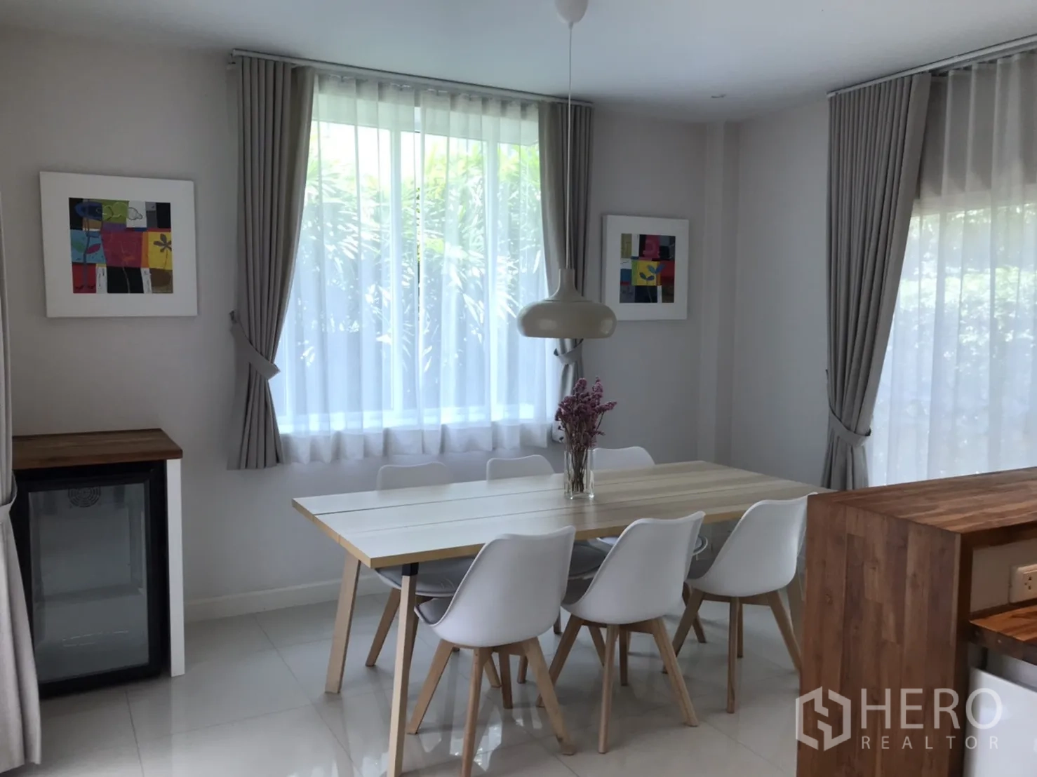 Detached House for rent or sale in Saphan Sung, Bangkok - Bright dining area with six-seat table, pendant lamp and curtained windows.
