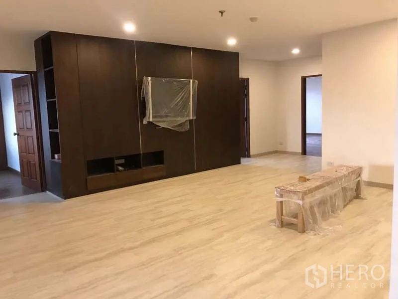 公寓 出售在Watthana, Bangkok - 客厅设整面深色木质电视墙与浅色地面。