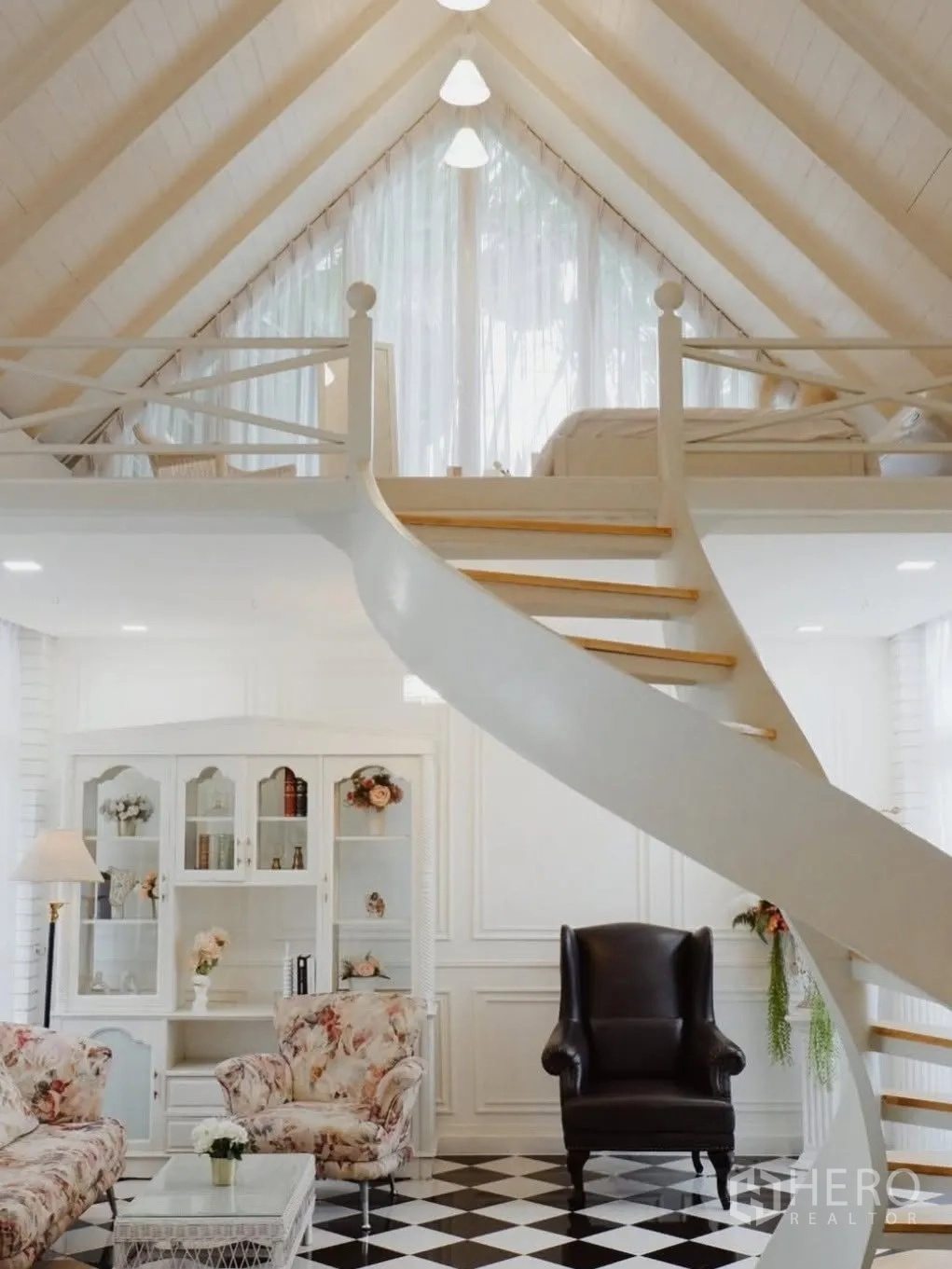 Detached House for rent in Phra Khanong, Bangkok - Loft mezzanine with a curved staircase and checkered floor living area.