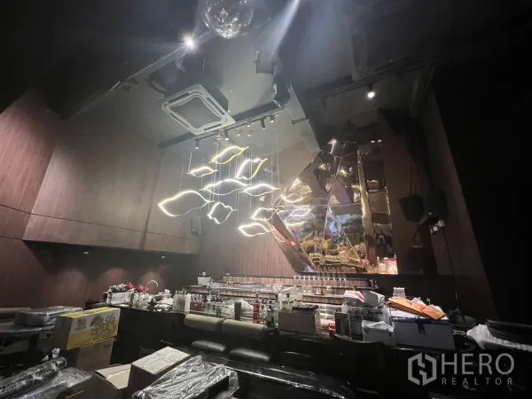 Shophouse for rent in Watthana, Bangkok - Bar area with mirrored feature wall and hanging LED lights above seating.