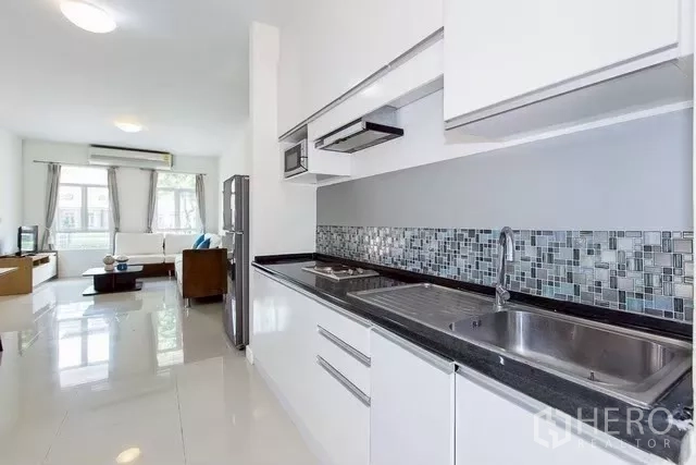 联排别墅 出租在Watthana, Bangkok - 一字型现代厨房，白色柜体、马赛克背墙与双水槽
