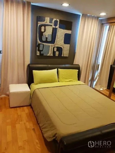 คอนโด ขายในBang Rak, Bangkok - ห้องนอนอบอุ่น เตียงบุนุ่ม ผ้าม่าน และงานศิลป์ที่ผนัง