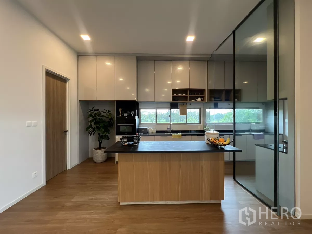 Detached House for rent in Saphan Sung, Bangkok - Modern kitchen with island, built-in appliances and floor-to-ceiling storage.