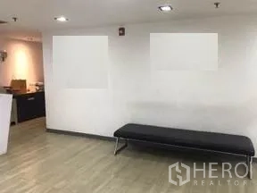 Office Space for rent in Khlong Toei, Bangkok - Lobby waiting area with a black bench under recessed ceiling lights.