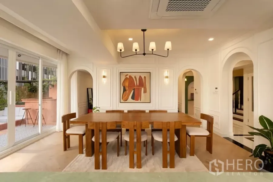 Condominium for sale in Watthana, Bangkok - Spacious dining room in Phrom Phong condominium with wooden table for eight and terrace access.