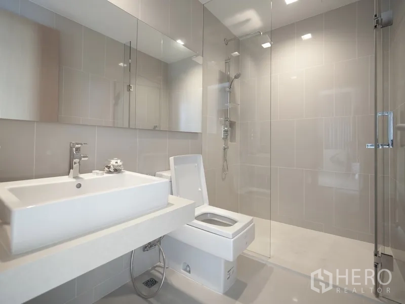 Condominium for rent in Watthana, Bangkok - Bright bathroom with glass shower, wall mirror and square basin