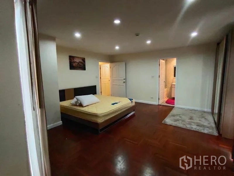 Condominium for rent or sale in Bang Rak, Bangkok - Master bedroom with en‑suite access, wood flooring, and ample closet space.