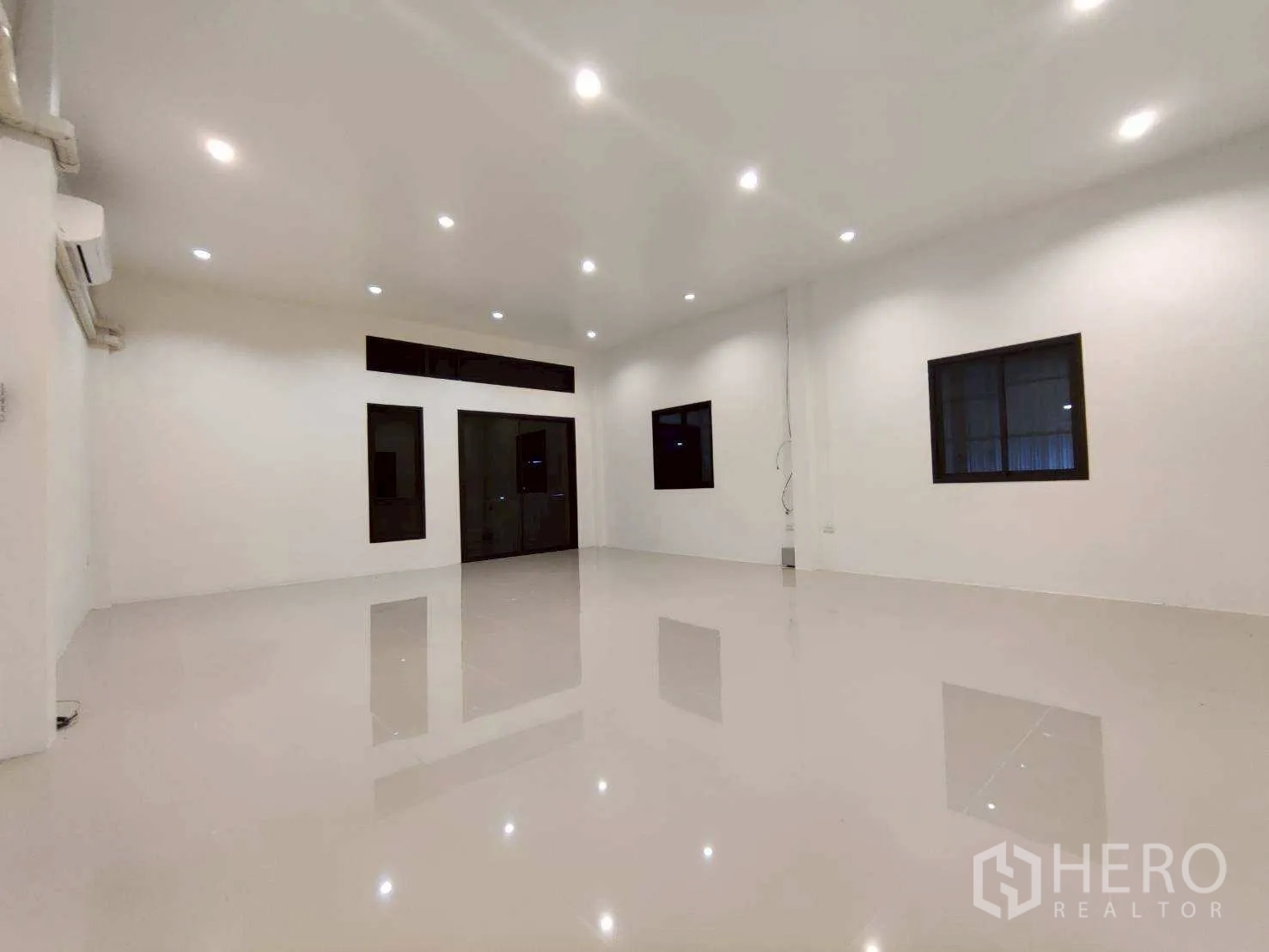 Warehouse for rent in Lam Luk Ka, Pathum Thani - Large office room with split air conditioning and multiple windows.