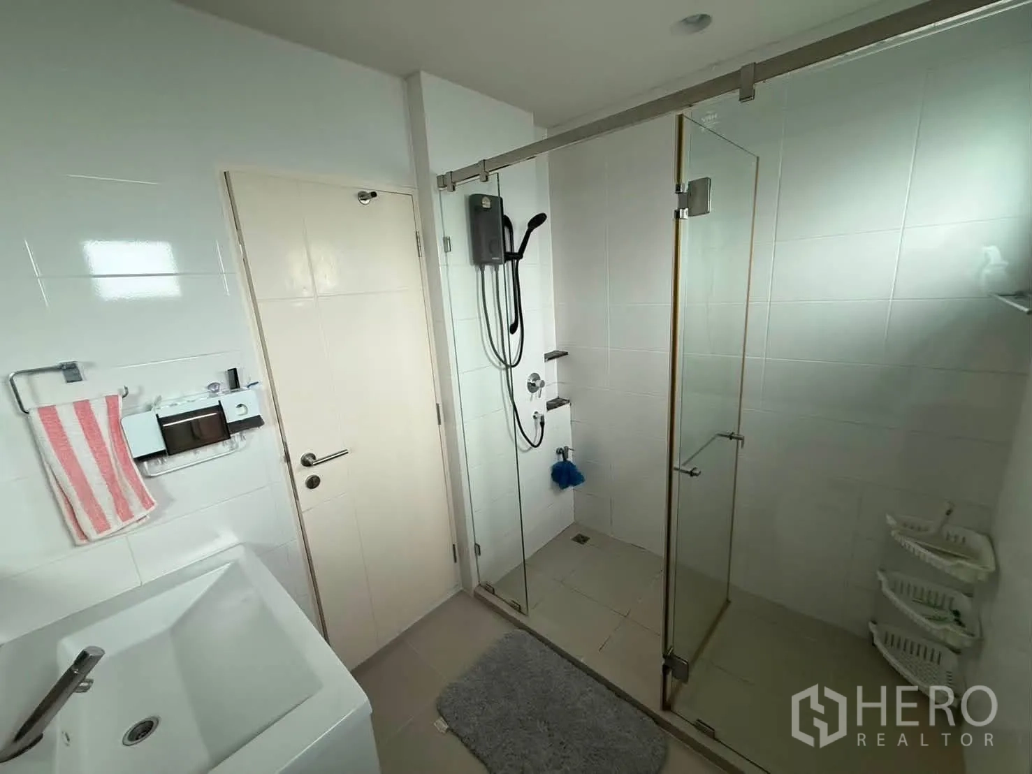 Detached House for rent in Bang Kapi, Bangkok - Bathroom with glass-enclosed shower, white vanity, and tiled walls.