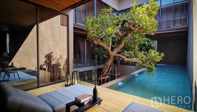 独立式住宅 出售在Lat Phrao, Bangkok - 遮蔽休憩平台，面向庭院绿树与私家泳池。