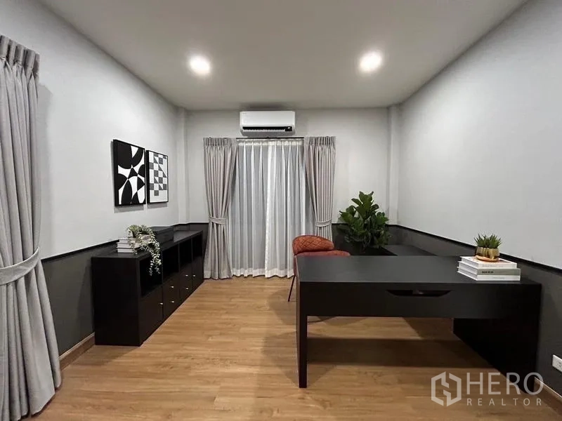 Detached House for rent or sale in Bang Phli, Samut Prakan - Home office with black desk, storage cabinets and a glass door with curtains.