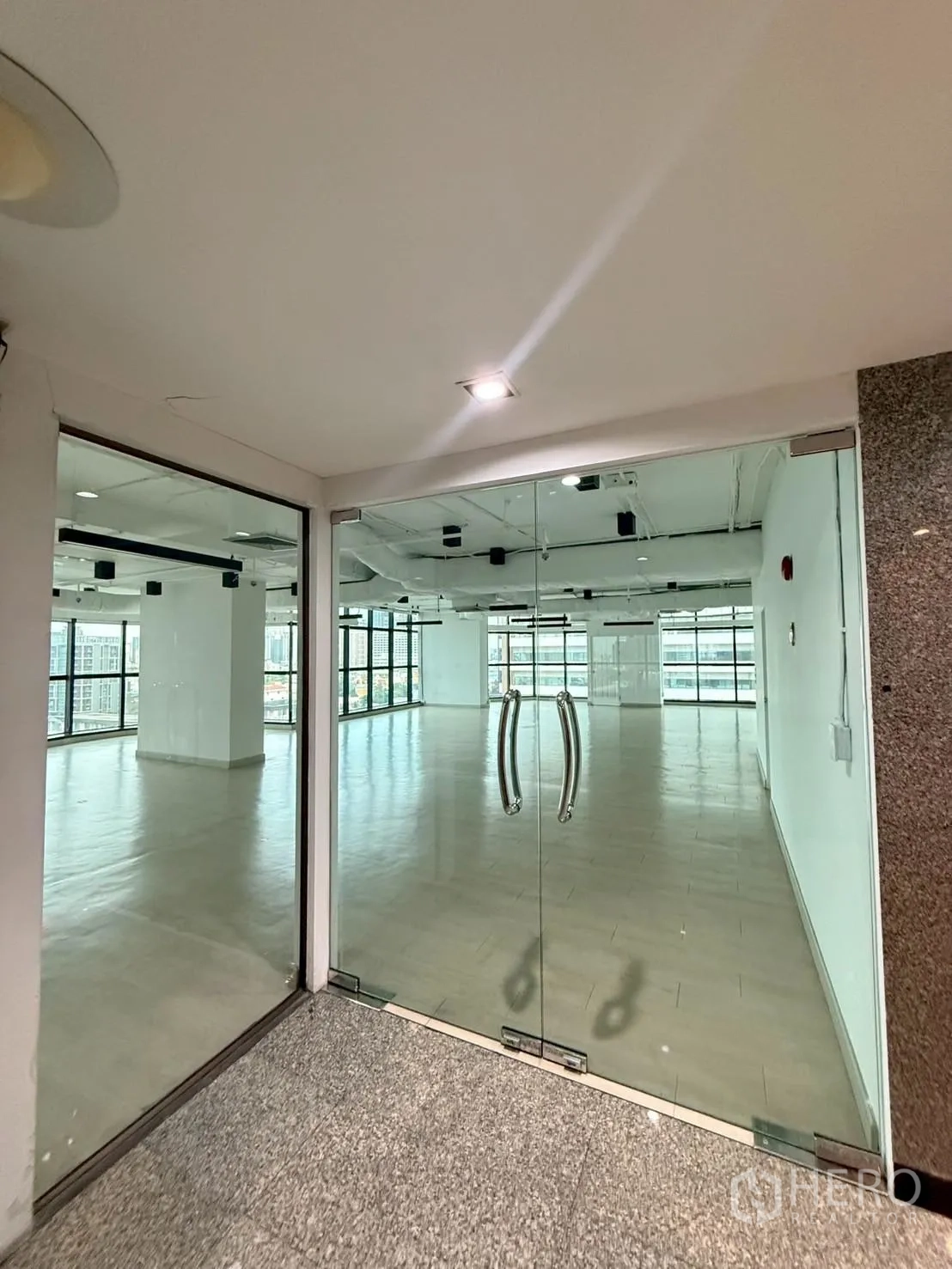 办公室 for rent in Watthana, Bangkok - 玻璃双开门通向明亮开阔的办公室与大窗景观。