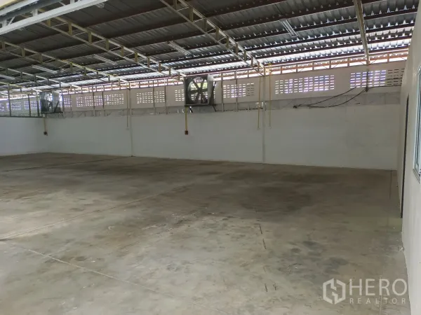Warehouse for rent in Suan Luang, Bangkok - Wide industrial floor area with wall-mounted exhaust fans and roof skylight strips for natural light.