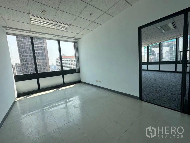 办公空间 出租在Khlong Toei, Bangkok - 带窗独立办公室，通过玻璃门与铺地毯区域相连。